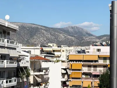 a group of buildings with a mountain in the background at Glyfada Center Apt 11 in Athens