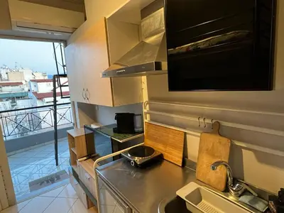 a kitchen with a sink and a view of a balcony at Terrace View Studio in Athens