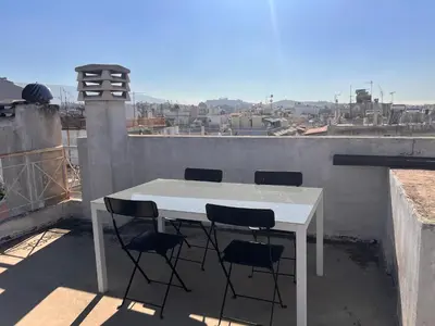 a white table and four chairs on a balcony at Terrace View Studio in Athens