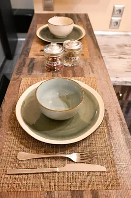 a table with two plates and a bowl and a fork at Kallithea Cozy Stonewall Studios in Athens