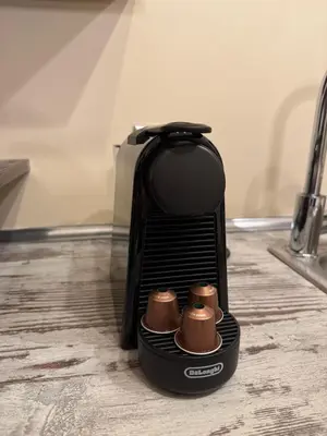 a black toaster sitting on a kitchen floor with two cups at Kallithea Cozy Stonewall Studios in Athens