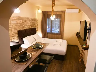 a room with a bed and a table with chairs at Kallithea Cozy Stonewall Studios in Athens