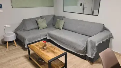 a living room with a gray couch and a table at Stella House near Metropolitan & Holargos Metro Station in Athens