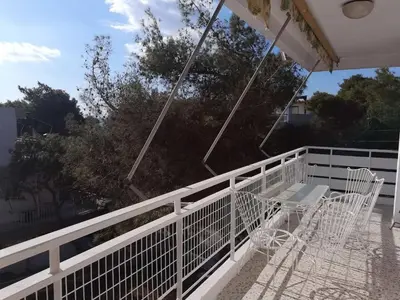 a white balcony with a table and chairs on it at Sunny with terrace around, sea view, 65 sqm in Saronida
