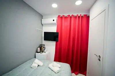 a bedroom with a red curtain and a bed with towels at Evaggelistrias 22 Suite by Zeus Suites in Athens