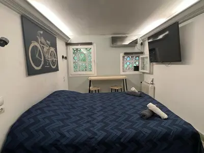 a bedroom with a blue bed and a tv at Athens Center Museum in Athens