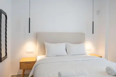 a bed with white sheets and pillows in a bedroom at Oasis Residence Athens in Athens