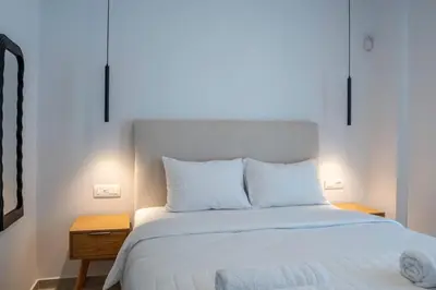 a bed with white sheets and pillows in a bedroom at Oasis Residence Athens in Athens