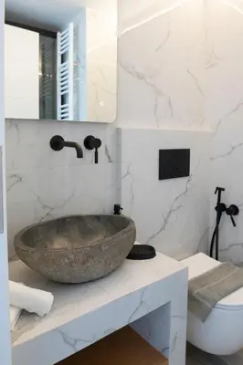 a bathroom with a large stone sink on a counter at Oasis Residence Athens in Athens
