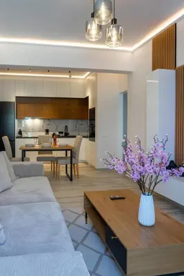 a living room with a vase of purple flowers on a table at Oasis Residence Athens in Athens