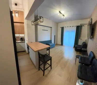 a living room with a table and chairs in a room at Evita's cozy Studio Next to Katehaki Metro in Athens