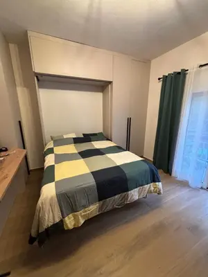 a bedroom with a black and white bed and a window at Evita's cozy Studio Next to Katehaki Metro in Athens