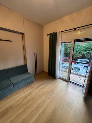 a living room with a couch and a sliding glass door at Evita's cozy Studio Next to Katehaki Metro in Athens