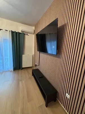 a living room with a flat screen tv on a wall at Evita's cozy Studio Next to Katehaki Metro in Athens