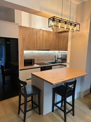 a kitchen with a wooden table and two chairs at Evita's cozy Studio Next to Katehaki Metro in Athens