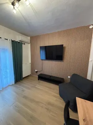 a living room with a couch and a flat screen tv at Evita's cozy Studio Next to Katehaki Metro in Athens