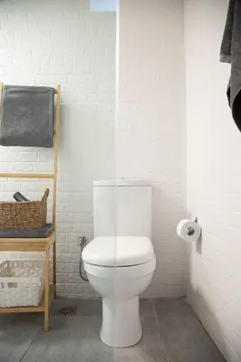 a white bathroom with a toilet and a roll of toilet paper at Central Urban Retreat in Athens