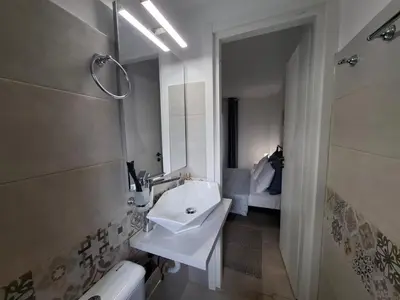 a white bathroom with a sink and a mirror at Iliana's Retreat by Greece Apartments in Athens