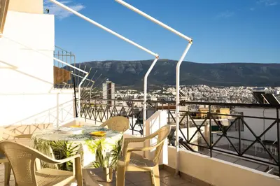 a table and chairs on a balcony with a view at Elegant Athenian Penthouse in Athens