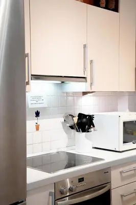 a kitchen with white cabinets and a counter top at Elegant Athenian Penthouse in Athens