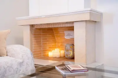 a living room with a brick fireplace with candles at Elegant Athenian Penthouse in Athens