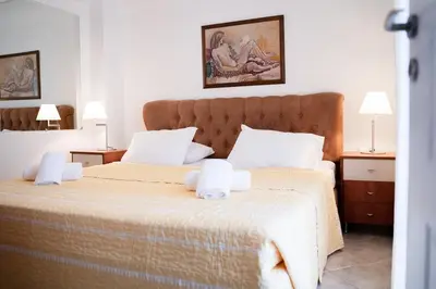 a bedroom with two beds with white sheets and two lamps at Elegant Athenian Penthouse in Athens
