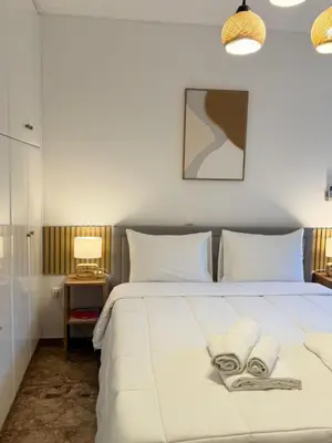 a bedroom with a large white bed with two white pillows at Boho Coastal Retreat with Jacuzzi, 1 min to Beach in Athens