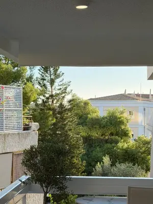 a balcony with a view of trees and a building at Boho Coastal Retreat with Jacuzzi, 1 min to Beach in Athens