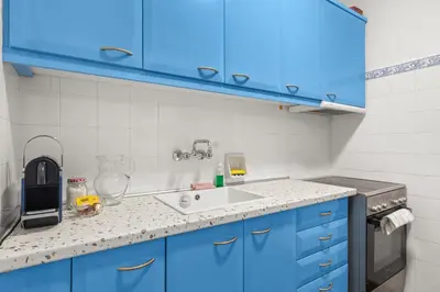a kitchen with blue cabinets and a sink at Boho Coastal Retreat with Jacuzzi, 1 min to Beach in Athens