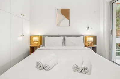 a bedroom with a white bed with towels on it at Boho Coastal Retreat with Jacuzzi, 1 min to Beach in Athens