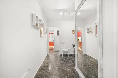 a hallway with white walls and a mirror at Boho Coastal Retreat with Jacuzzi, 1 min to Beach in Athens
