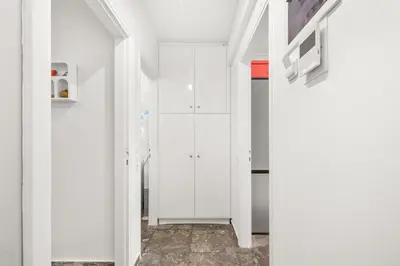 a white kitchen with white cabinets and a hallway at Boho Coastal Retreat with Jacuzzi, 1 min to Beach in Athens