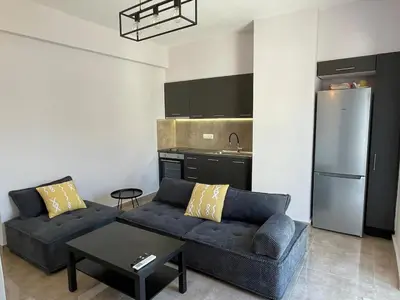 a living room with a couch and a kitchen at Casa del Rey in Piraeus
