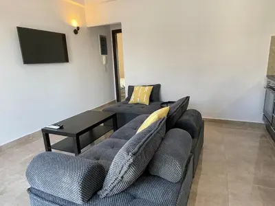 a living room with two couches and a tv at Casa del Rey in Piraeus