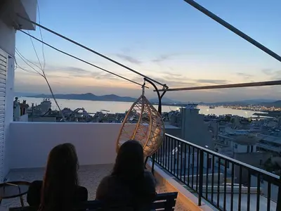 two people sitting on a balcony looking at the city at Casa del Rey in Piraeus