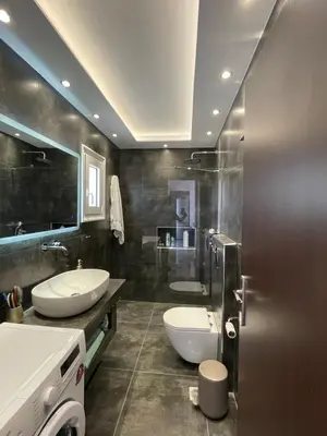 a bathroom with two sinks and a toilet at Casa del Rey in Piraeus