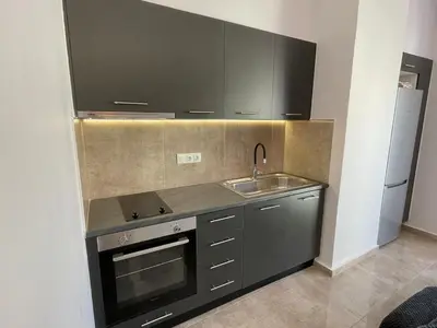 a kitchen with black cabinets and a sink and a refrigerator at Casa del Rey in Piraeus