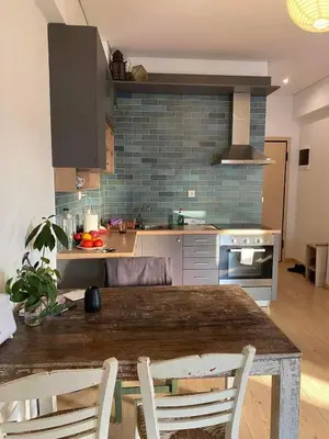 a kitchen with a wooden table with chairs in it at 7th floor bright penthouse in quiet pedestrian in Athens