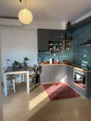a kitchen with a table and a table and a dining room at 7th floor bright penthouse in quiet pedestrian in Athens