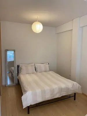a bedroom with a bed and a light fixture at 7th floor bright penthouse in quiet pedestrian in Athens