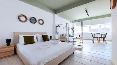 a bedroom with a large bed and a dining room at Modern comfort and city vibes just steps from Athe in Athens