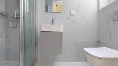 a white bathroom with a sink and a shower at Modern comfort and city vibes just steps from Athe in Athens