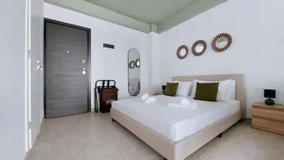 a bedroom with a large white bed and a mirror at Modern comfort and city vibes just steps from Athe in Athens