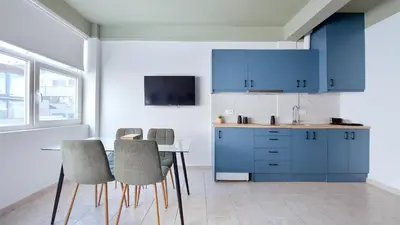 a kitchen with blue cabinets and a table and chairs at Modern comfort and city vibes just steps from Athe in Athens