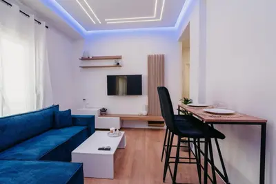 a living room with a blue couch and a table at Apartment 49 Athens in Athens