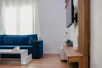 a living room with a blue couch and a table at Apartment 49 Athens in Athens