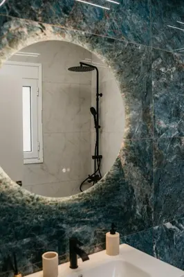 a bathroom with a round mirror over a sink at Apartment 49 Athens in Athens
