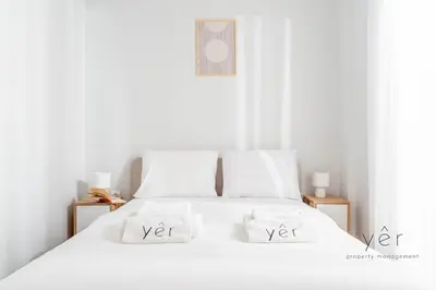 a white bed with two white pillows on it at Elegant & Modern 2BR Apartment - Pireaus Center and Marina in Piraeus
