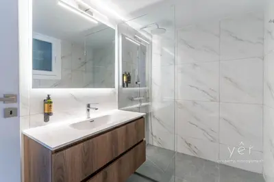 a white bathroom with a sink and a shower at Elegant & Modern 2BR Apartment - Pireaus Center and Marina in Piraeus