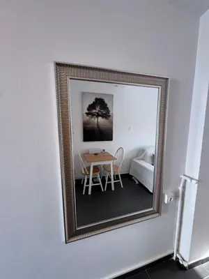 a mirror on a wall with a table and a bed at Krezias Apartments K1 Acropolis View & Jacuzzi ! in Athens